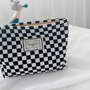 Black and white checkerboard canvas cosmetic bag, stylish minimalist square makeup storage pouch.