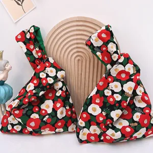 Detailed view of Japanese knot fabric wrist bag with cute floral cat print for daily carry.