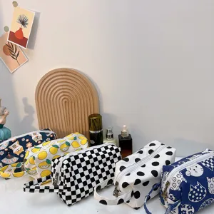Primer plano de neceser de lona con estampado de cuadros, limones y gatos para uso de viaje.