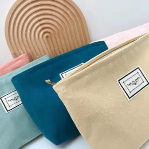 Semplice borsa cosmetica in tela con cerniera ed etichetta per viaggi e uso quotidiano.