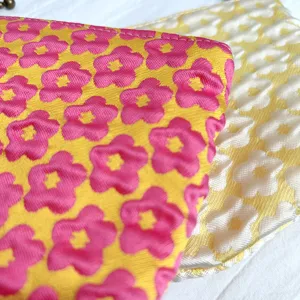 Nahaufnahme der süßen Blumen-Kosmetik Tasche, weiche Textur mit farbenfrohem Blütenmuster.