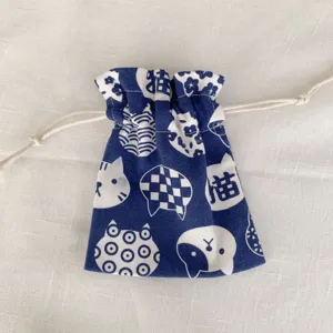 Nahaufnahme des blauen Stoffbeutels mit Kordelzug, süßen Katzenmustern und feiner Textur.