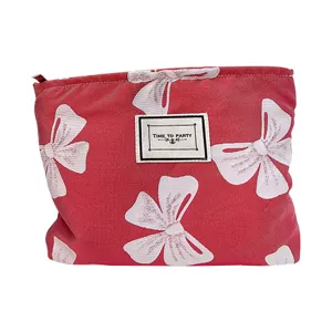 Tragbare rote Kosmetiktasche mit weißem Schleifenprint, stilvolle Make-up-Aufbewahrung.