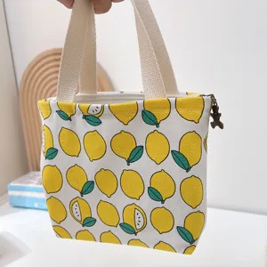 Vista detallada del bolso de lona con estampado de limón amarillo, cremallera y asas resistentes.