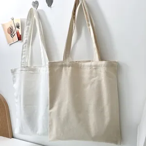 Detailaufnahme minimalistischer, lässiger Stofftaschen in Weiß und Beige an der Wand.