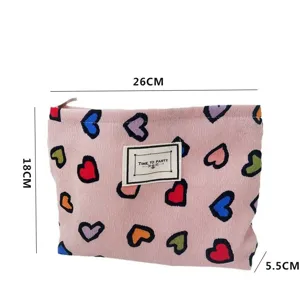 Vista dettagliata della borsa cosmetica rosa in tela con cuori colorati e chiusura a zip pratica.
