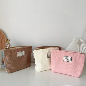 Corduroy cosmetic bag detail, soft fabric texture, smooth zipper closure, travel organizer.