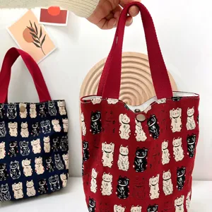 Close-up detail of cute lucky cat printed canvas tote bag showcasing pattern and fabric texture.