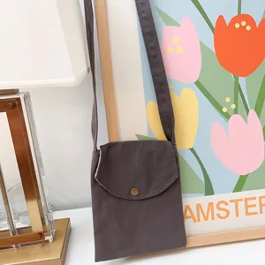 Detail der kleinen Canvas Umhängetasche, vertikale Handytasche mit Überschlag und Druckknopf.
