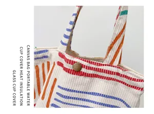 Nahaufnahme Detail der bunten gestreiften Canvas Kord Handtasche mit Metall Druckknopf.