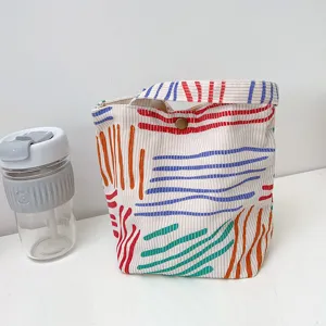 Detailaufnahme einer stilvollen Cord-Lunchtasche mit bunten gestreiften Mustern.