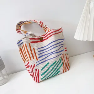 Detailansicht der farbig gestreiften Cordschultasche mit einzigartiger Textur und Linien.