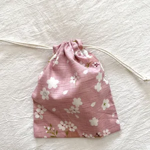 Rosa blumiger Kordelzug Aufbewahrungsbeutel Detail mit Stofftextur und Kirschblütendruck.