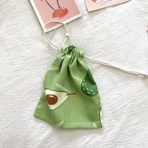 Detailansicht des grünen Baumwoll-Kordelzugsacks mit Avocadomotiv für Kosmetik und Kleinigkeiten.