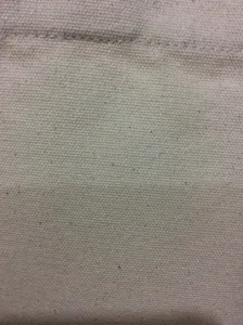 Detailansicht der strapazierfähigen 12oz Canvas Stofftextur mit sauberer Nahtverarbeitung.