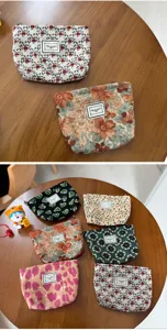 Corduroy floral zipper makeup pouch detail, portable travel cosmetic storage bag design.