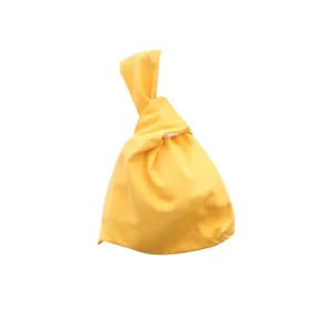 Minimalist yellow Japanese knot wrist bag, casual fabric handbag for phone, keys and small items.