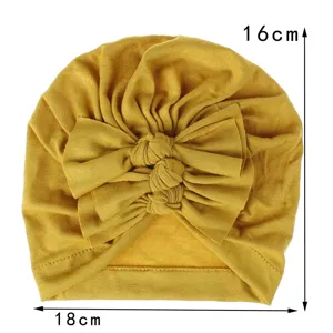 Soft knit baby turban hat with double bow knot, mustard yellow infant headwear, detail view.