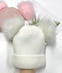 Detail view of double pom pom winter knit beanie hat, soft warm cozy thick hat for women.