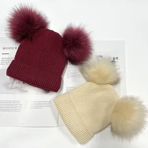 Detailed view of cute parent-child double pom-pom winter knit beanies in cozy plush warm style.