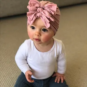 Cute baby bow hat detail, soft knitted infant turban headwear for lovely spring and summer days.