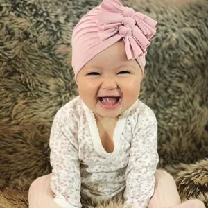 Cute baby pink knitted bow turban hat, soft pleated infant beanie cap for daily wear.
