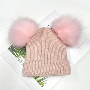 Cute pink double pom-pom knit beanie for women and kids. Cozy winter warm knitted hat.