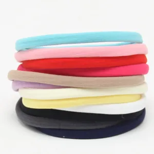 Close-up of colorful nylon baby headbands stack, soft elastic hair bands set for kids.