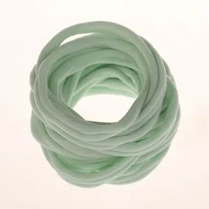Detail shot of light green elastic nylon hair bands, soft texture for DIY baby headbands.