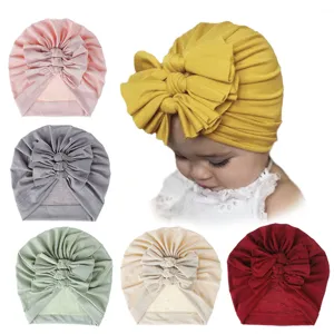 Details of the soft knitted baby turban hat featuring a pleated bow design in multiple colors.