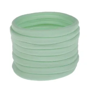 Light green elastic nylon hair ties closeup, soft baby headband DIY accessories stack