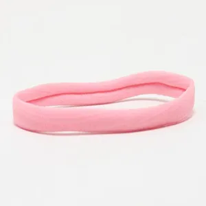 Close-up view of the pink elastic baby headband showing soft fabric and stretchy quality.