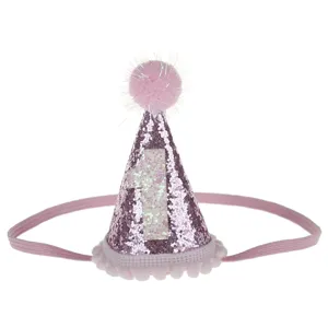 Vista dettagliata del cappello di compleanno rosa glitterato per bambini con pon pon e fascia.