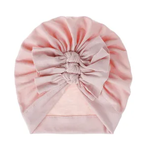 Soft pink baby turban hat detail featuring cute triple knot bows and comfortable knit fabric.