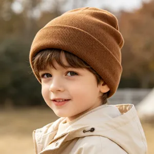 Children knitted beanie hat detail view, warm winter fleece cap in brown solid color.