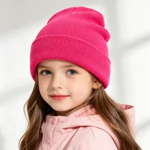 Child bright pink knit beanie close-up, soft warm winter wool hat worn by a cute young model.