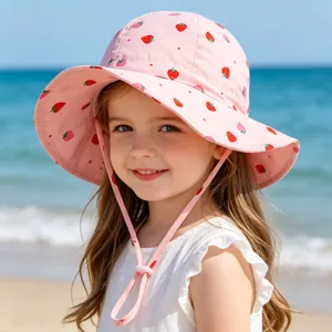 Adorable pink bucket hat with strawberry print detail, perfect for sunny beach days.