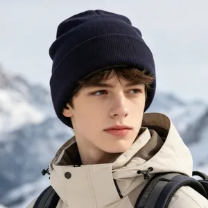 Close-up detail of warm winter knitted beanie hat worn in outdoor snowy mountain scenery.
