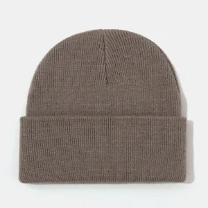 Close-up detail shot of a classic brown ribbed knitted beanie, showing soft texture and folded edge.