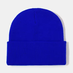 Close-up detail shot of a bright blue knitted winter beanie hat with a cuffed design.