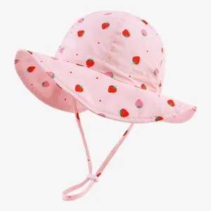 Detailed view of pink baby bucket hat with cute strawberry print and adjustable chin strap.
