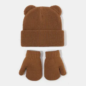 Detailansicht der niedlichen braunen Strickmütze mit Bärenohren und passenden Winterhandschuhen.