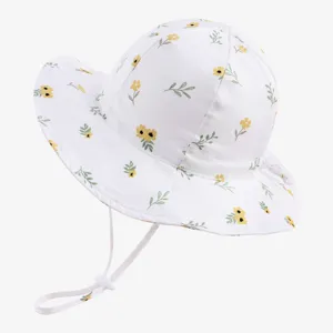 Detailed view of white baby bucket hat with yellow floral pattern and windproof chin strap.