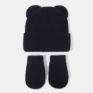 Nahaufnahme von der schwarzen Strickmütze mit Bärenohren und passenden Handschuhen.