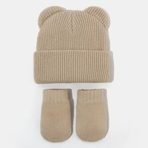 Nahaufnahme Details der beige Strick Winter Babymütze und Handschuhe Set mit süßem Bärenohren.