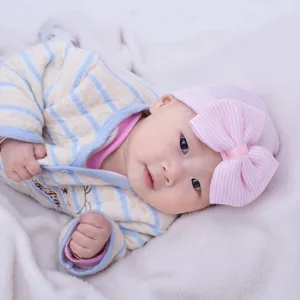 Primer plano detallado del tierno gorro de punto para bebé con un gran lazo rosa y suave.