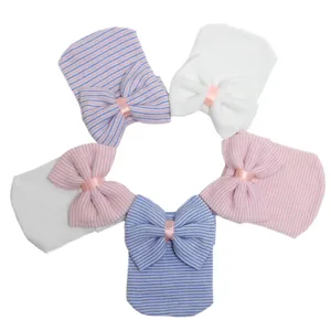 Primer plano de los detalles de gorros tejidos para recién nacidos con elegantes lazos decorativos.