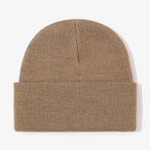 Brown knit beanie close-up detail, cozy winter ribbed cuffed hat texture, warm outdoor headwear.
