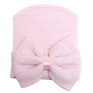 Detalle en primer plano del bonito gorro de punto para recién nacido con gran lazo de rayas.
