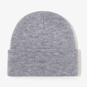 Close-up detail of grey knitted beanie, showing soft wool texture and rolled cuff design.